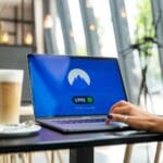 Osoba w kawiarni korzysta z laptopa z włączonym VPN