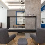 Minimalistyczne studio z fotelami przy kominku w aneksie kuchennym