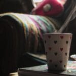 Parujący kubek w serduszka w przytulnym wnętrzu